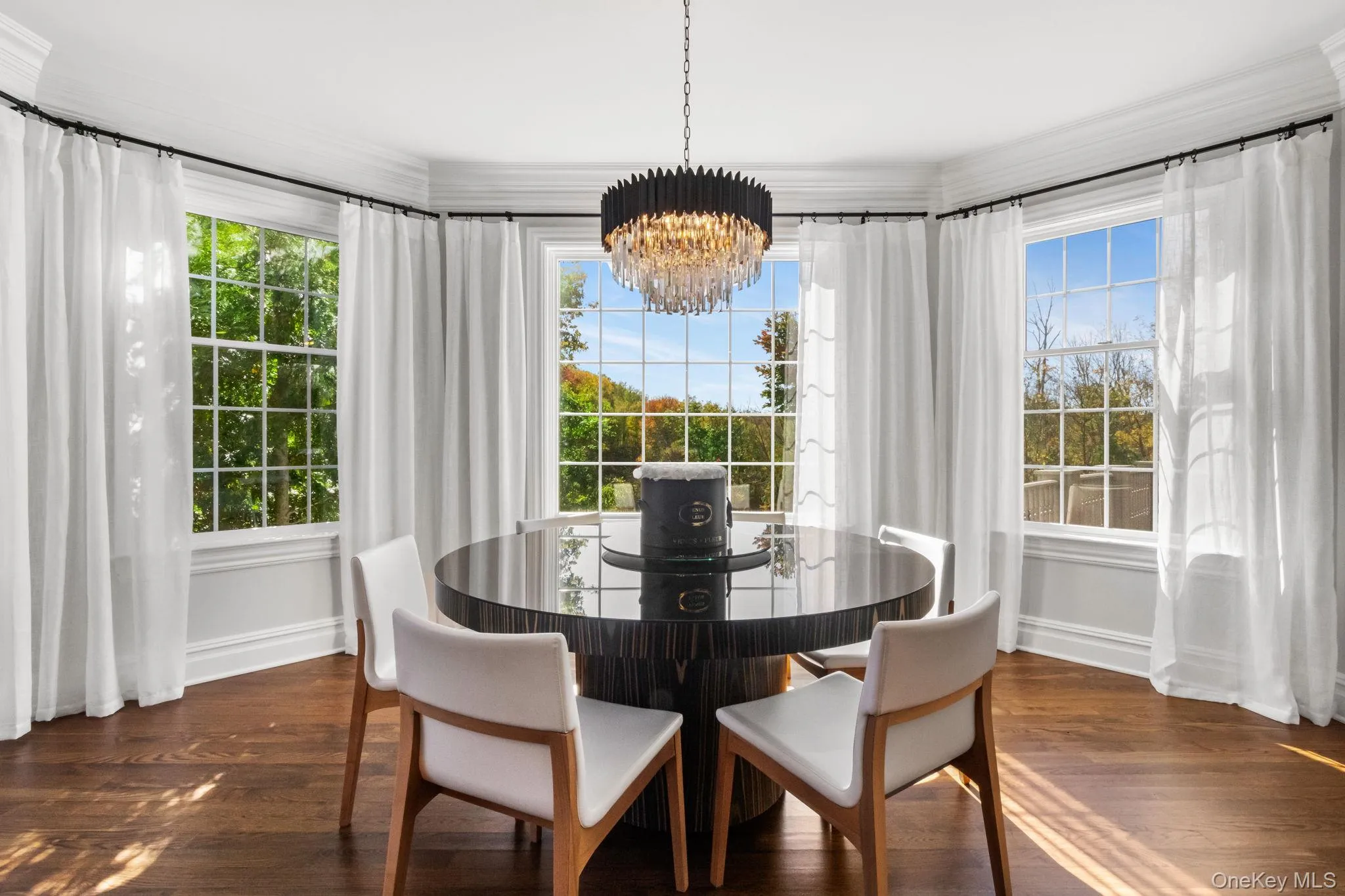 Dining area featuring a chandelier, dark wood finished floors, and crown molding Dining area featuring a chandelier, dark wood finished floors, and crown molding