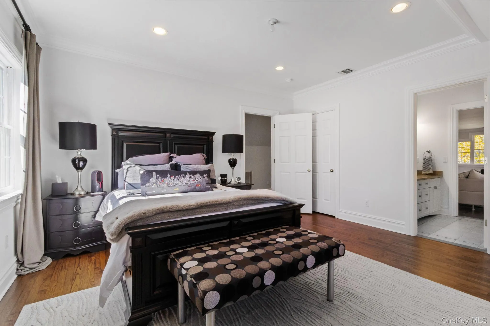 Bedroom with wood finished floors, crown molding, recessed lighting, and connected bathroom Bedroom with wood finished floors, crown molding, recessed lighting, and connected bathroom