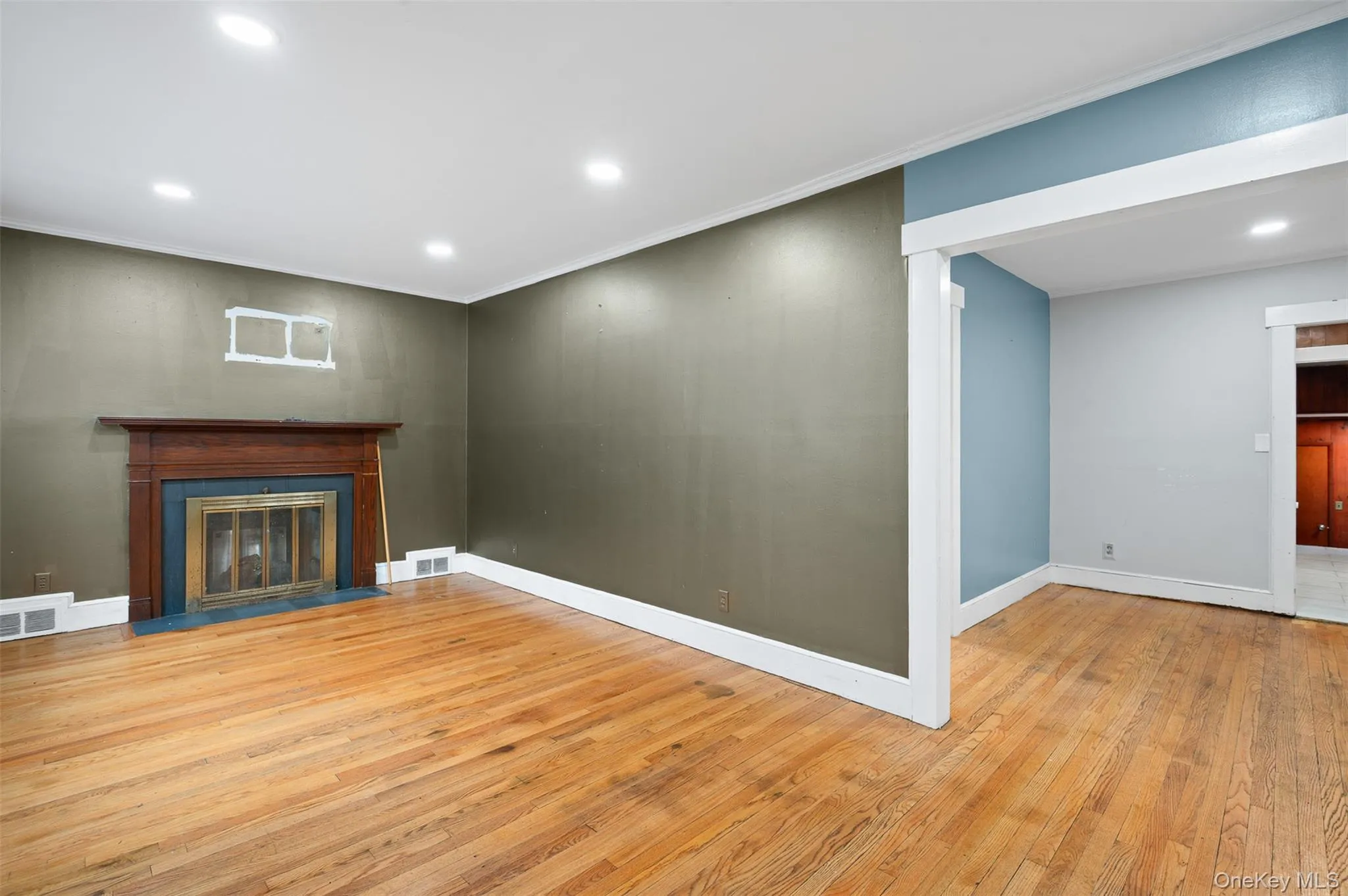 Unfurnished living room featuring recessed lighting, light wood-type flooring, crown molding, and a fireplace with flush hearth Unfurnished living room featuring recessed lighting, light wood-type flooring, crown molding, and a fireplace with flush hearth