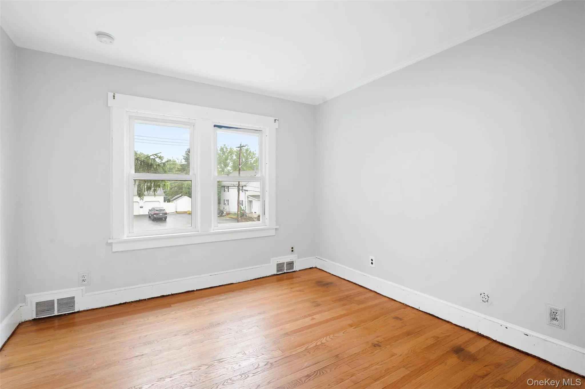 Spare room with light wood-type flooring and ornamental molding Spare room with light wood-type flooring and ornamental molding