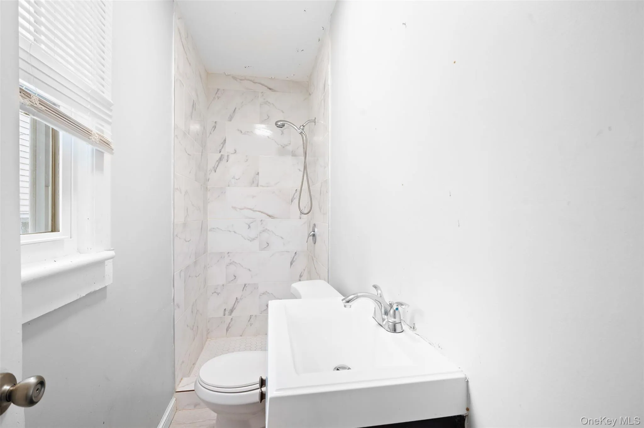 Bathroom featuring a marble finish shower and vanity Bathroom featuring a marble finish shower and vanity