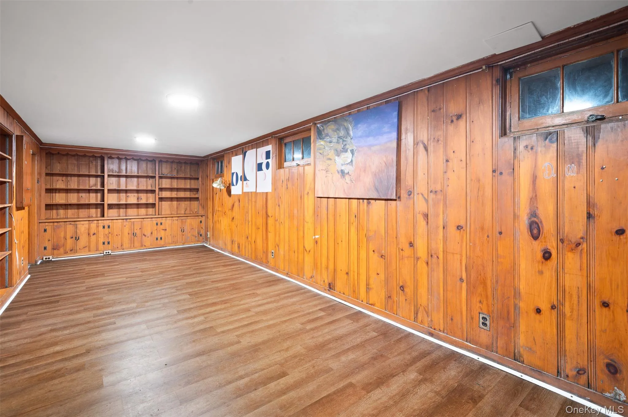 Unfurnished room featuring wood finished floors and wood walls Unfurnished room featuring wood finished floors and wood walls