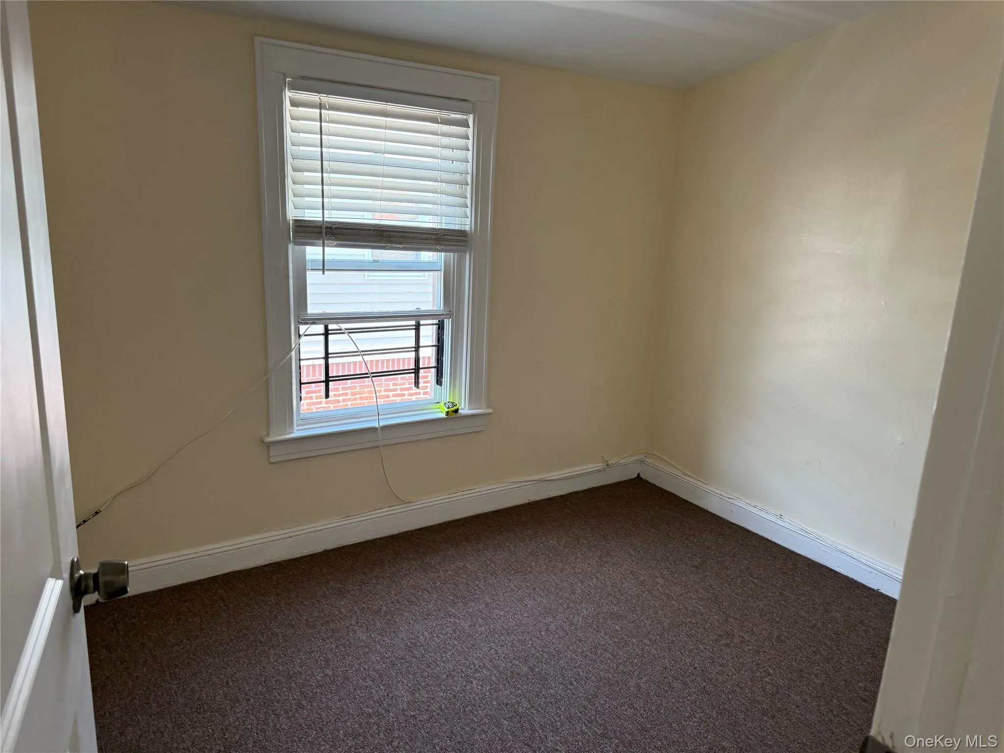 Unfurnished room with carpet flooring and baseboards Unfurnished room with carpet flooring and baseboards