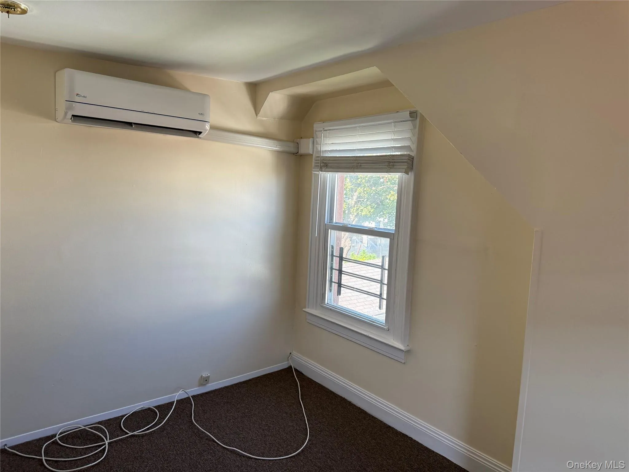 Additional living space featuring a wall mounted air conditioner and carpet floors Additional living space featuring a wall mounted air conditioner and carpet floors