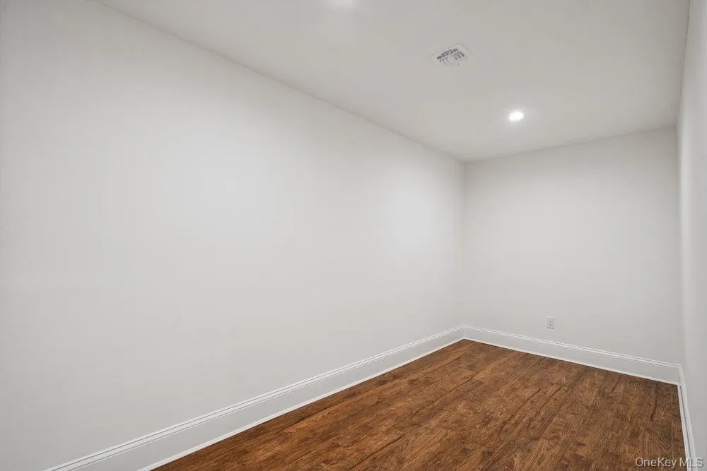 Empty room with dark wood-style flooring and recessed lighting Empty room with dark wood-style flooring and recessed lighting