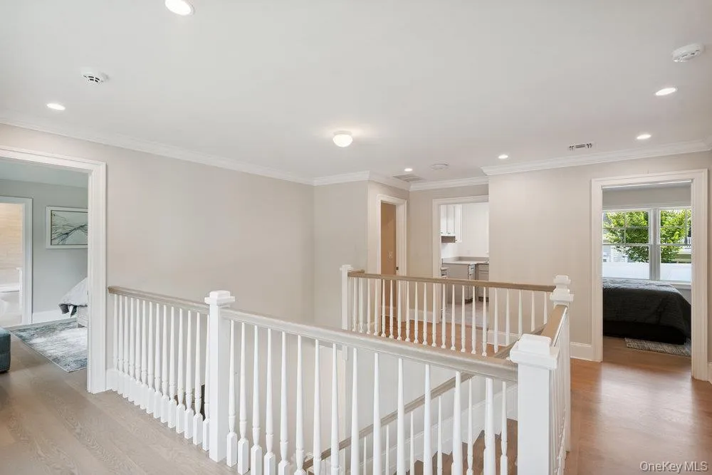 Hallway with light wood-type flooring, recessed lighting, an upstairs landing, and crown molding Hallway with light wood-type flooring, recessed lighting, an upstairs landing, and crown molding
