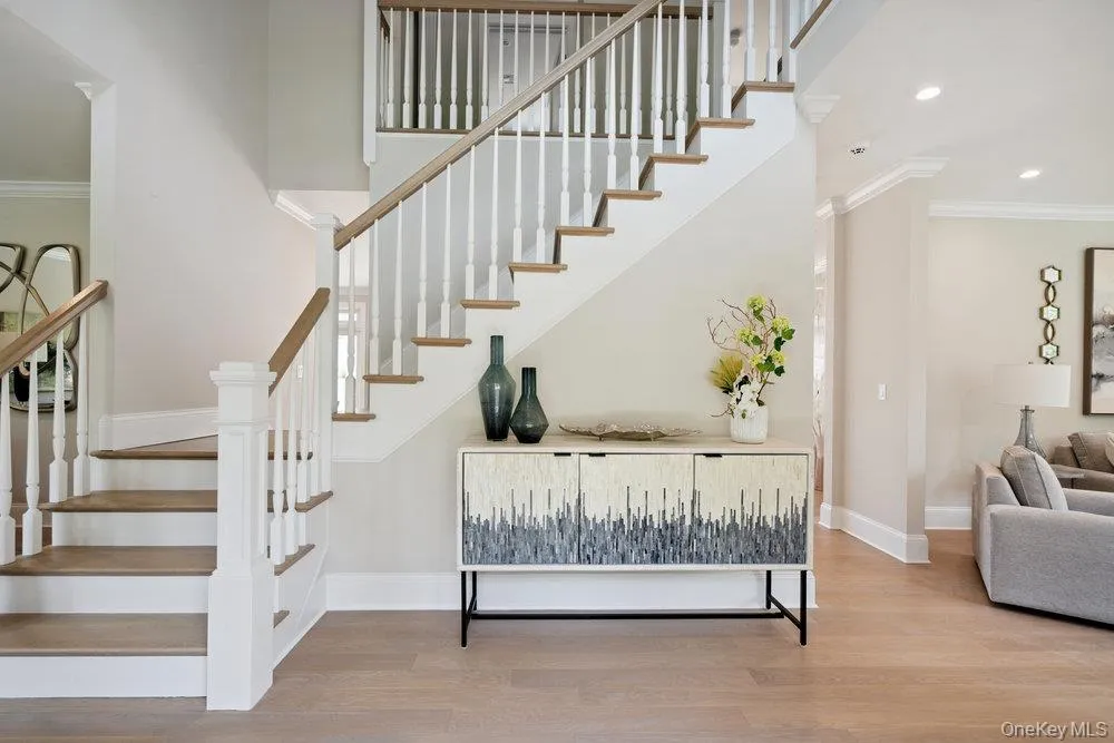 Stairs with ornamental molding, wood finished floors, and recessed lighting Stairs with ornamental molding, wood finished floors, and recessed lighting