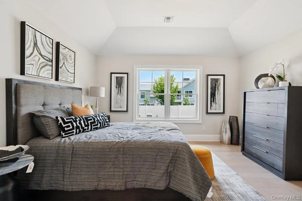 Bedroom with wood finished floors and vaulted ceiling Bedroom with wood finished floors and vaulted ceiling