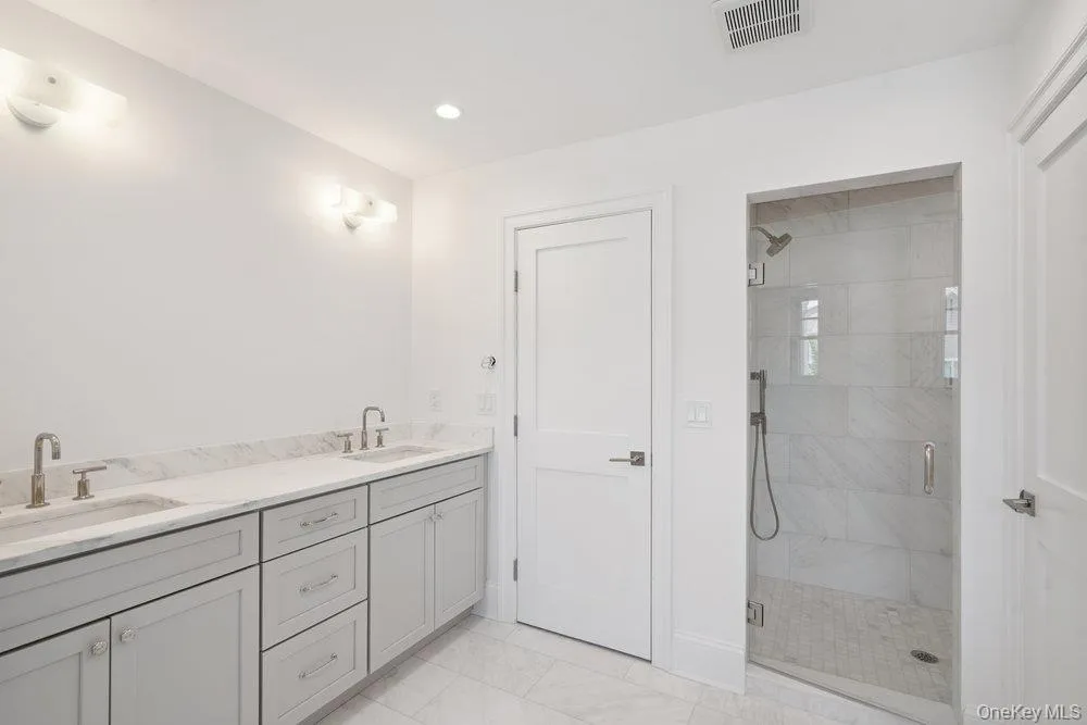 Bathroom featuring double vanity, a stall shower, and recessed lighting Bathroom featuring double vanity, a stall shower, and recessed lighting