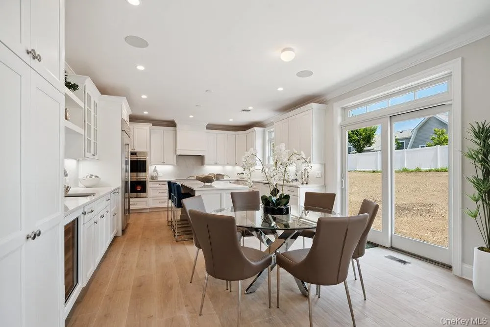 Dining space featuring light wood-style flooring, recessed lighting, beverage cooler, and crown molding Dining space featuring light wood-style flooring, recessed lighting, beverage cooler, and crown molding