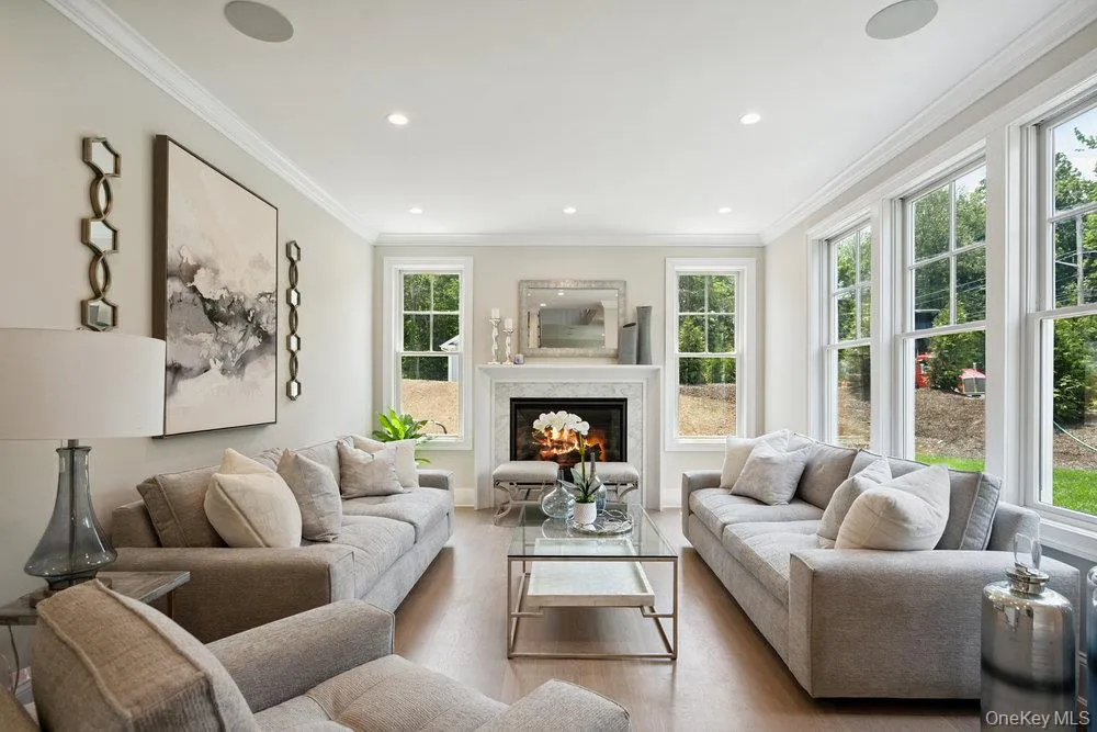 Living area featuring crown molding, a high end fireplace, wood finished floors, and recessed lighting Living area featuring crown molding, a high end fireplace, wood finished floors, and recessed lighting