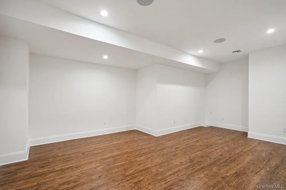 Finished below grade area with recessed lighting and dark wood finished floors Finished below grade area with recessed lighting and dark wood finished floors
