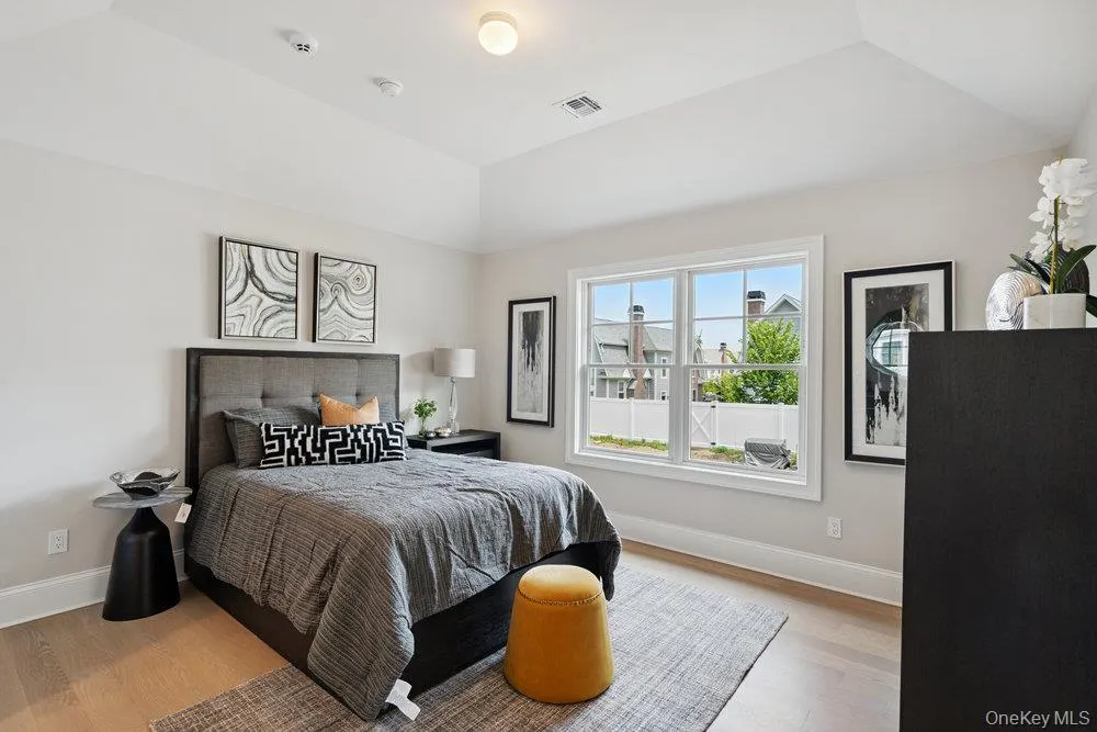 Bedroom with light wood finished floors and vaulted ceiling Bedroom with light wood finished floors and vaulted ceiling