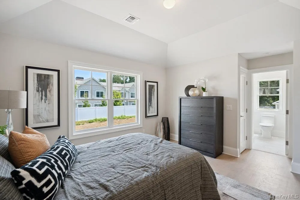 Bedroom featuring wood finished floors and multiple windows Bedroom featuring wood finished floors and multiple windows