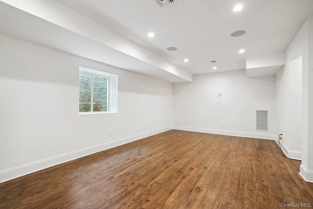 Empty room featuring dark wood-type flooring and recessed lighting Empty room featuring dark wood-type flooring and recessed lighting