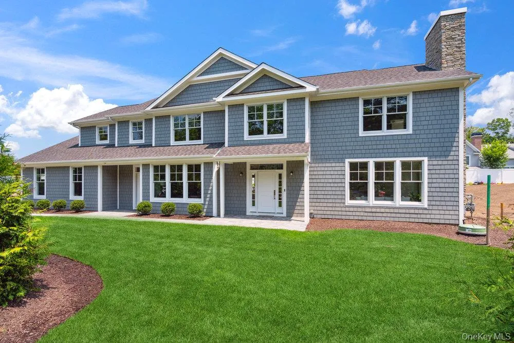 View of front of house with a shingled roof, a chimney, a front yard, and a porch View of front of house with a shingled roof, a chimney, a front yard, and a porch