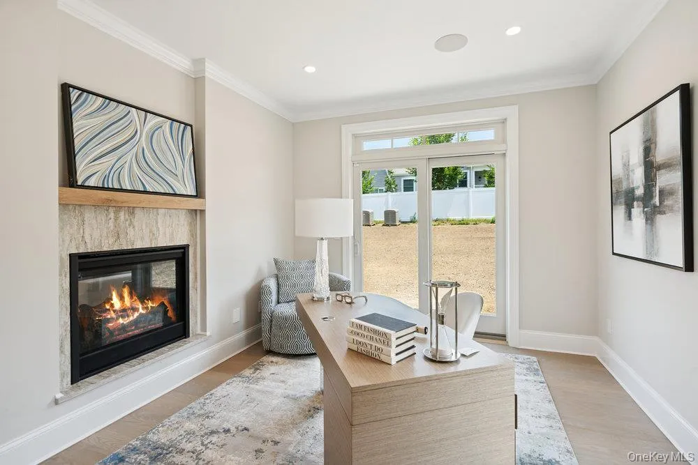 Office area featuring wood finished floors, a glass covered fireplace, crown molding, and recessed lighting Office area featuring wood finished floors, a glass covered fireplace, crown molding, and recessed lighting