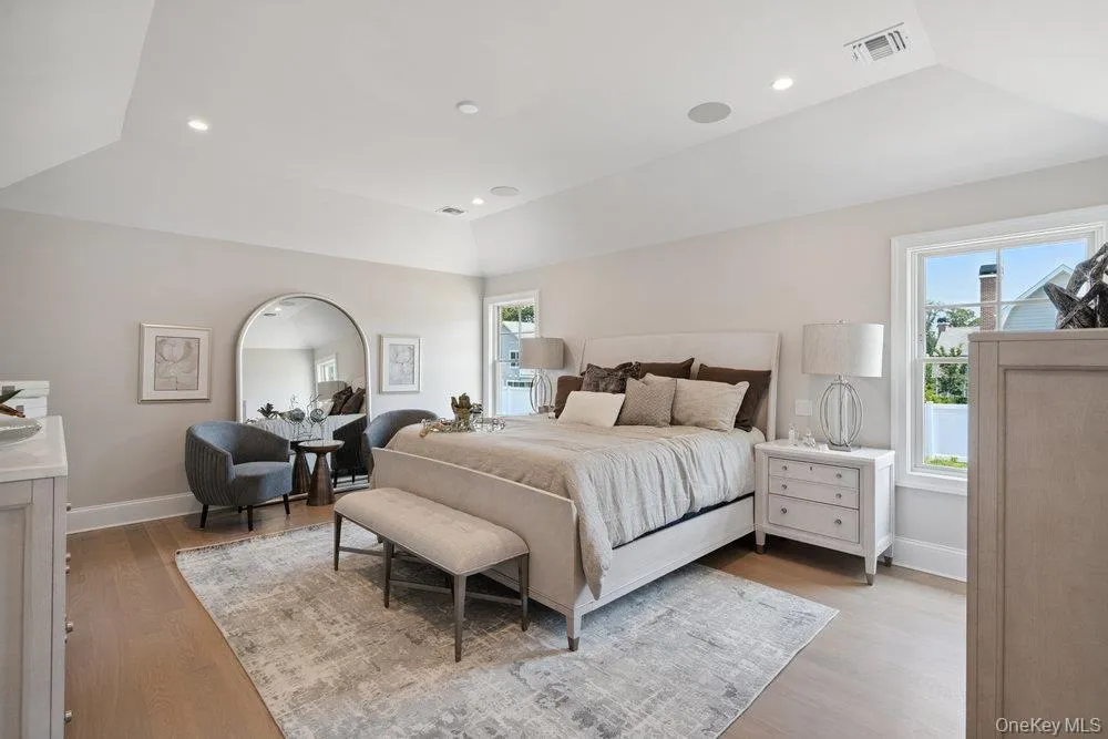 Bedroom featuring a raised ceiling, multiple windows, light wood-type flooring, and recessed lighting Bedroom featuring a raised ceiling, multiple windows, light wood-type flooring, and recessed lighting