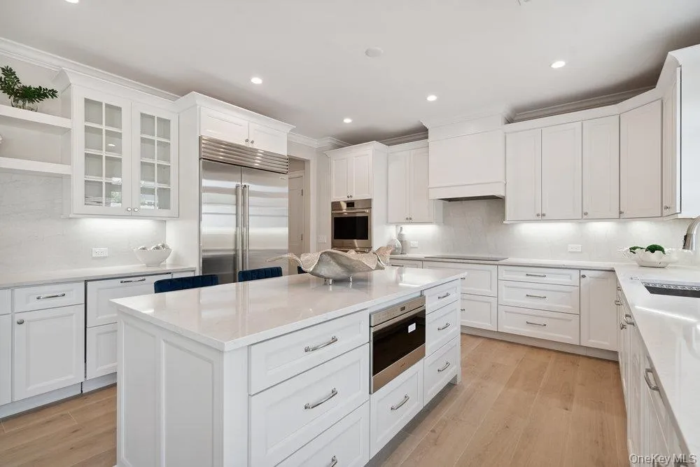 Kitchen with decorative backsplash, glass insert cabinets, open shelves, light wood-style flooring, and recessed lighting Kitchen with decorative backsplash, glass insert cabinets, open shelves, light wood-style flooring, and recessed lighting