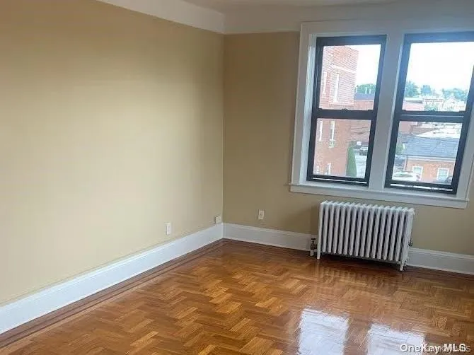 Empty room with radiator heating unit and baseboards Empty room with radiator heating unit and baseboards