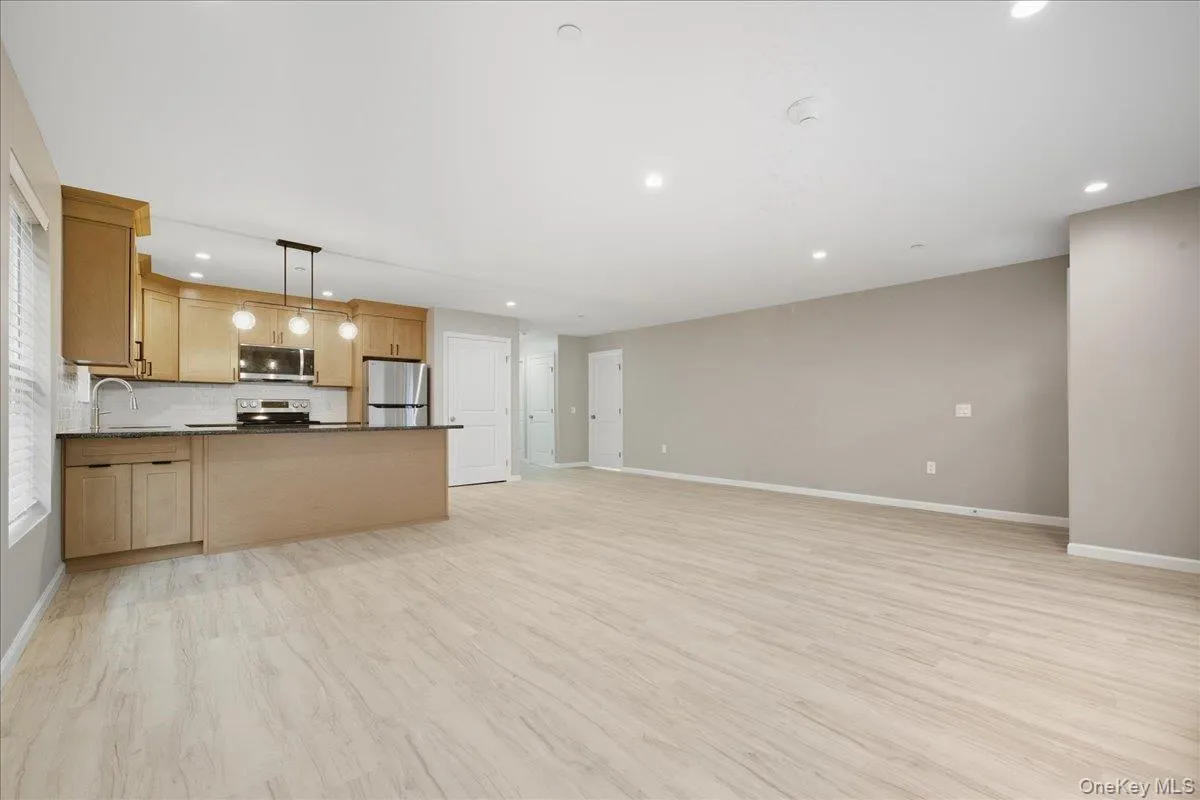 Kitchen Open To Dining Area with Peninsula & Pendant Lighting, Luxury Vinyl Plank Floors, Stainless Steel Appliances, Granite Countertops & Tile Backsplash Kitchen Open To Dining Area with Peninsula & Pendant Lighting, Luxury Vinyl Plank Floors, Stainless Steel Appliances, Granite Countertops & Tile Backsplash