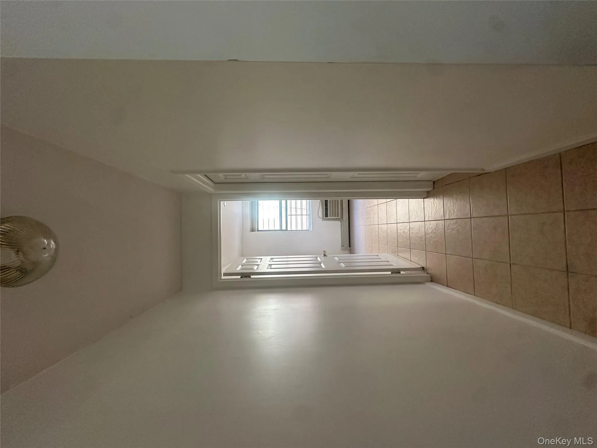 Corridor featuring light tile patterned floors and baseboards Corridor featuring light tile patterned floors and baseboards