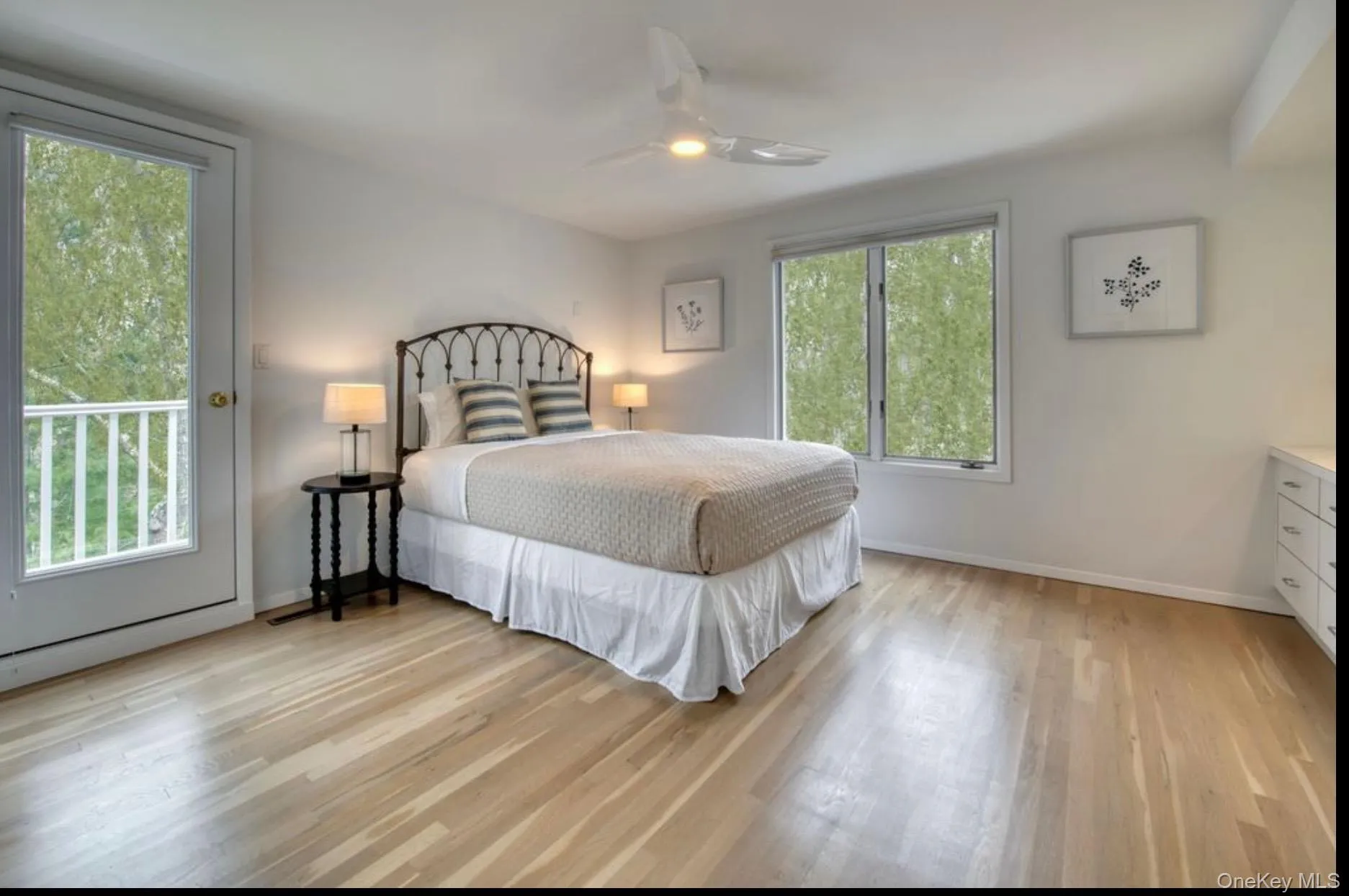Bedroom featuring light wood-style flooring, access to exterior, and a ceiling fan Bedroom featuring light wood-style flooring, access to exterior, and a ceiling fan
