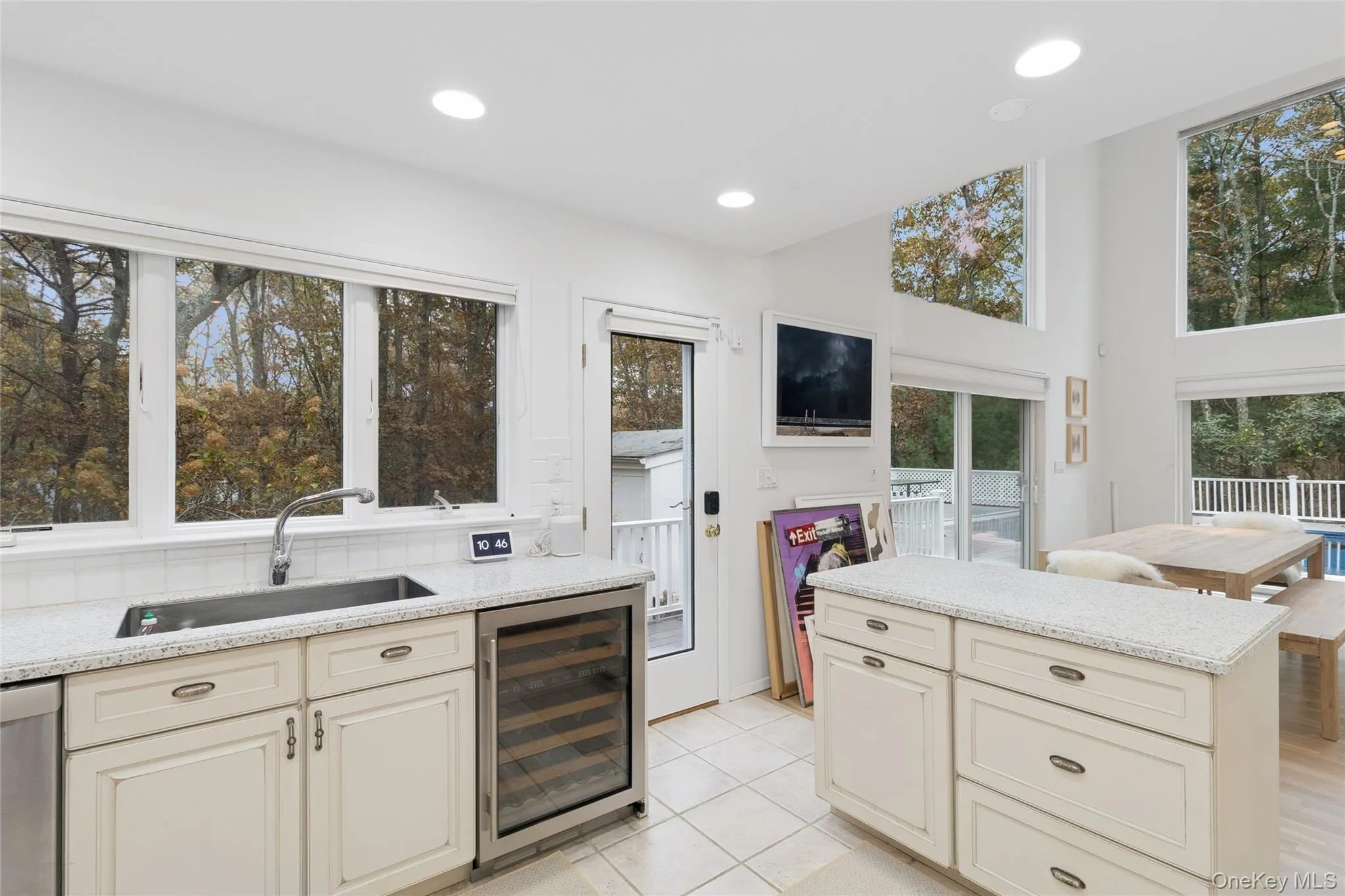 Kitchen featuring cream cabinetry, light stone countertops, wine cooler, and recessed lighting Kitchen featuring cream cabinetry, light stone countertops, wine cooler, and recessed lighting