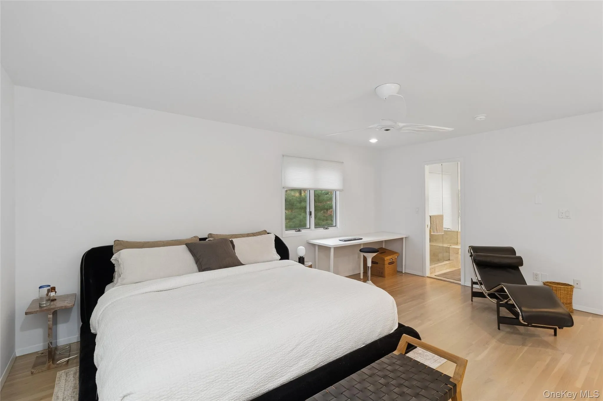 Bedroom with light wood-style flooring, a ceiling fan, and ensuite bathroom Bedroom with light wood-style flooring, a ceiling fan, and ensuite bathroom