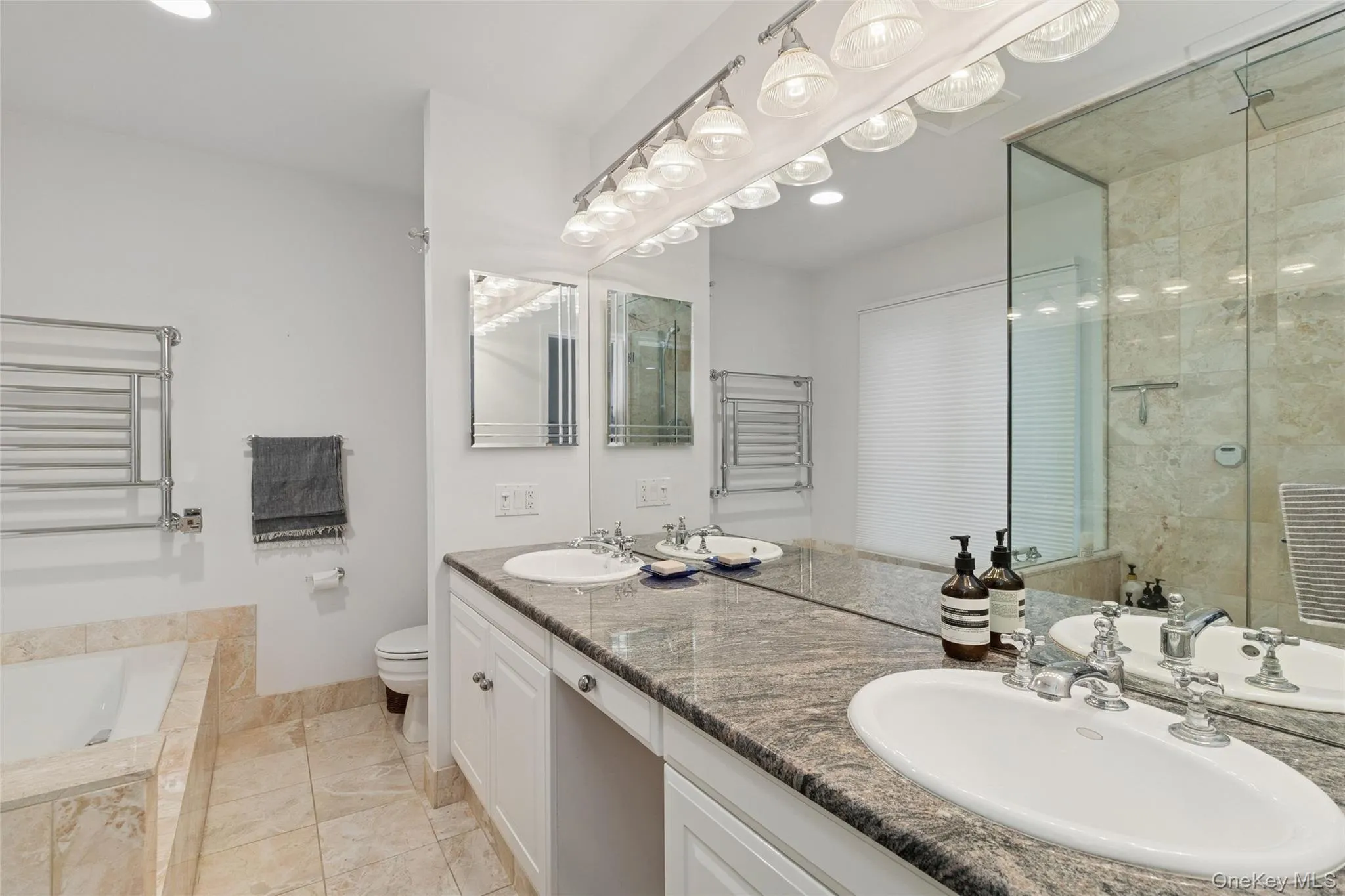 Bathroom with double vanity, a garden tub, a towel warmer, a stall shower, and recessed lighting Bathroom with double vanity, a garden tub, a towel warmer, a stall shower, and recessed lighting