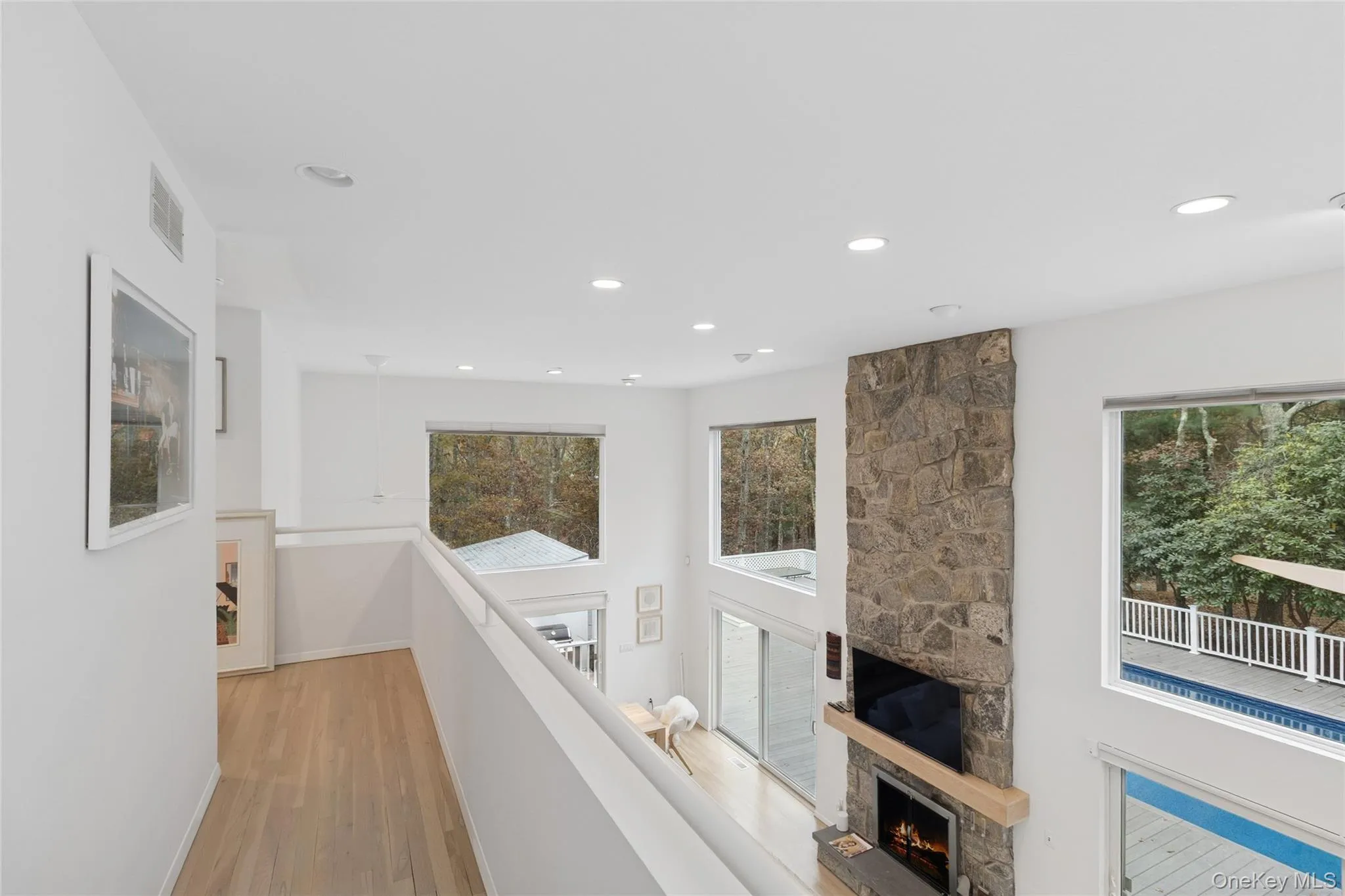 Hall featuring light wood-type flooring, recessed lighting, plenty of natural light, and an upstairs landing Hall featuring light wood-type flooring, recessed lighting, plenty of natural light, and an upstairs landing