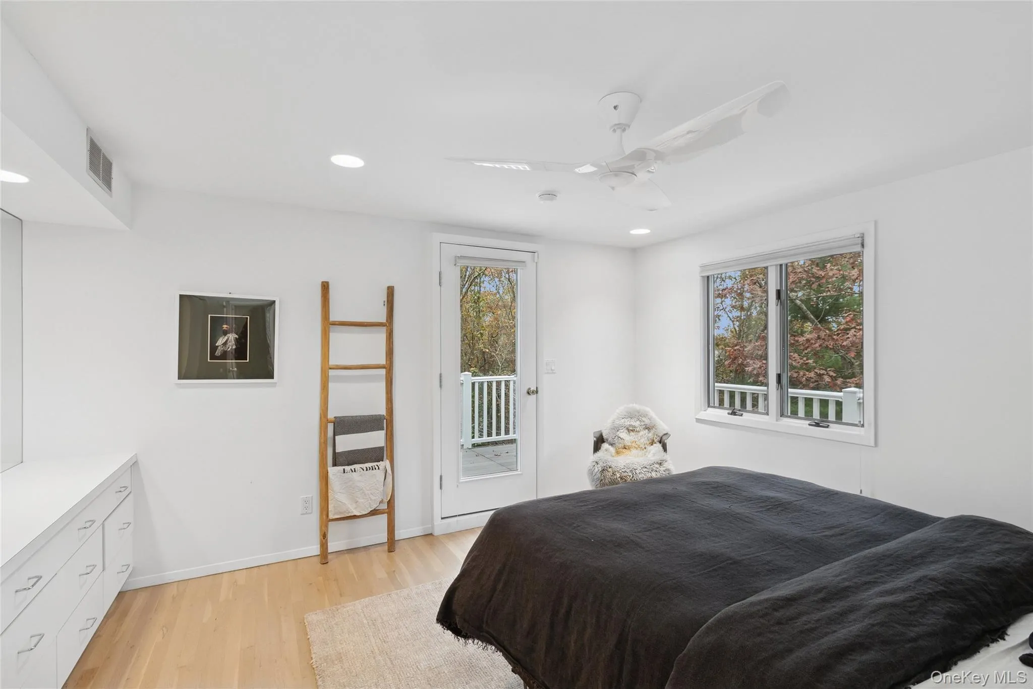 Bedroom featuring access to exterior, light wood-type flooring, a ceiling fan, recessed lighting, and multiple windows Bedroom featuring access to exterior, light wood-type flooring, a ceiling fan, recessed lighting, and multiple windows