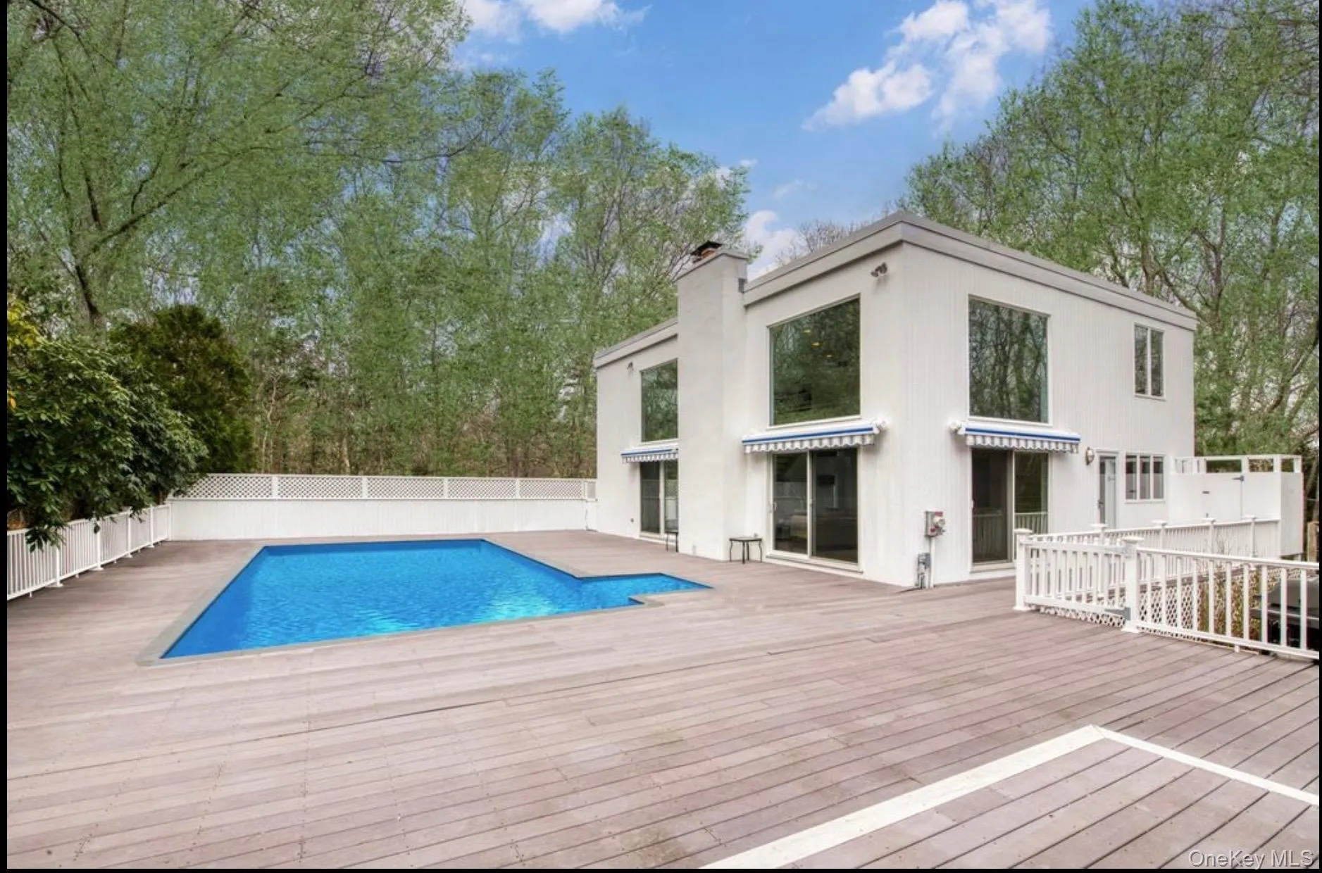 View of swimming pool featuring a wooden deck and a fenced backyard View of swimming pool featuring a wooden deck and a fenced backyard