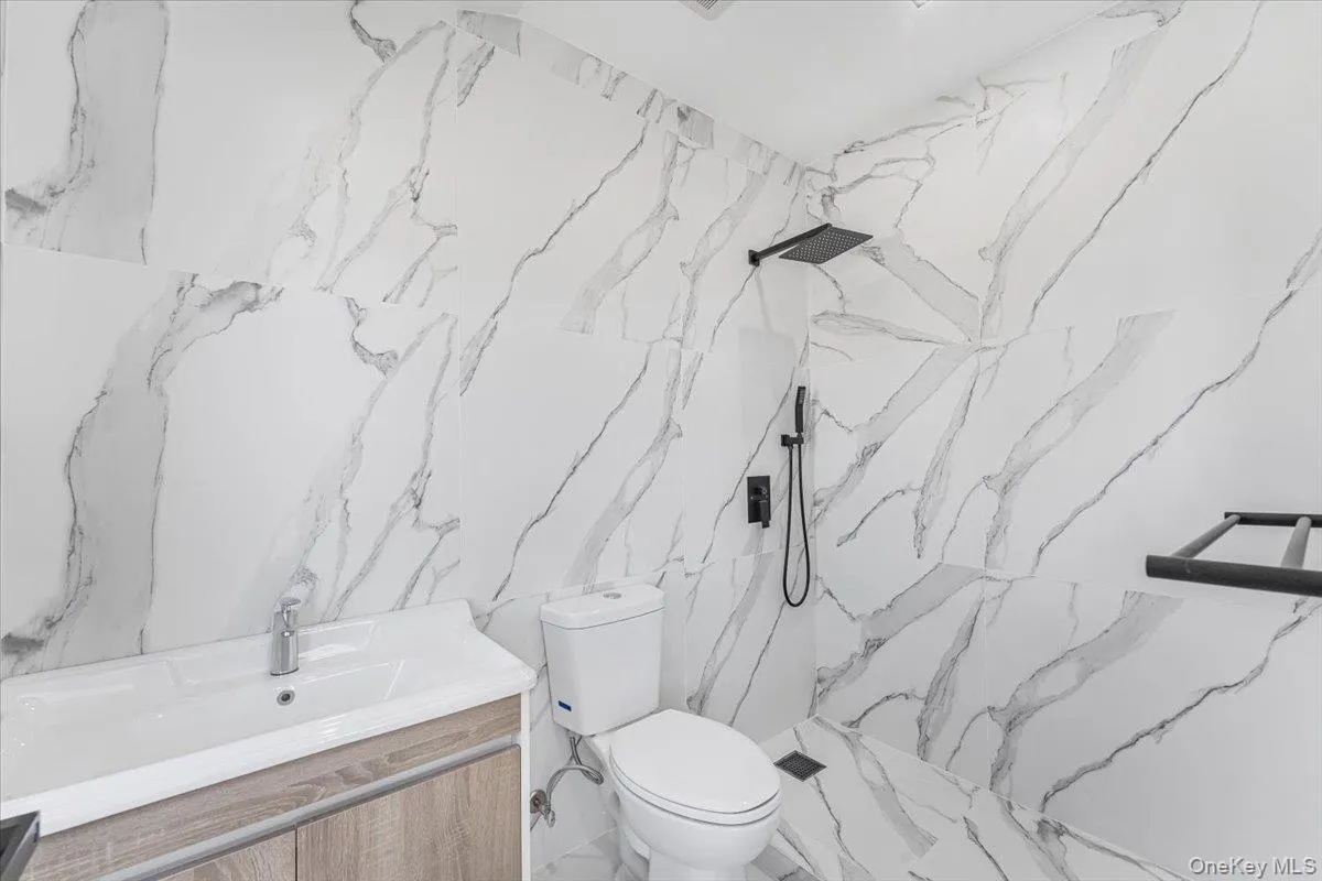 Full bath with vanity and a marble finish shower Full bath with vanity and a marble finish shower