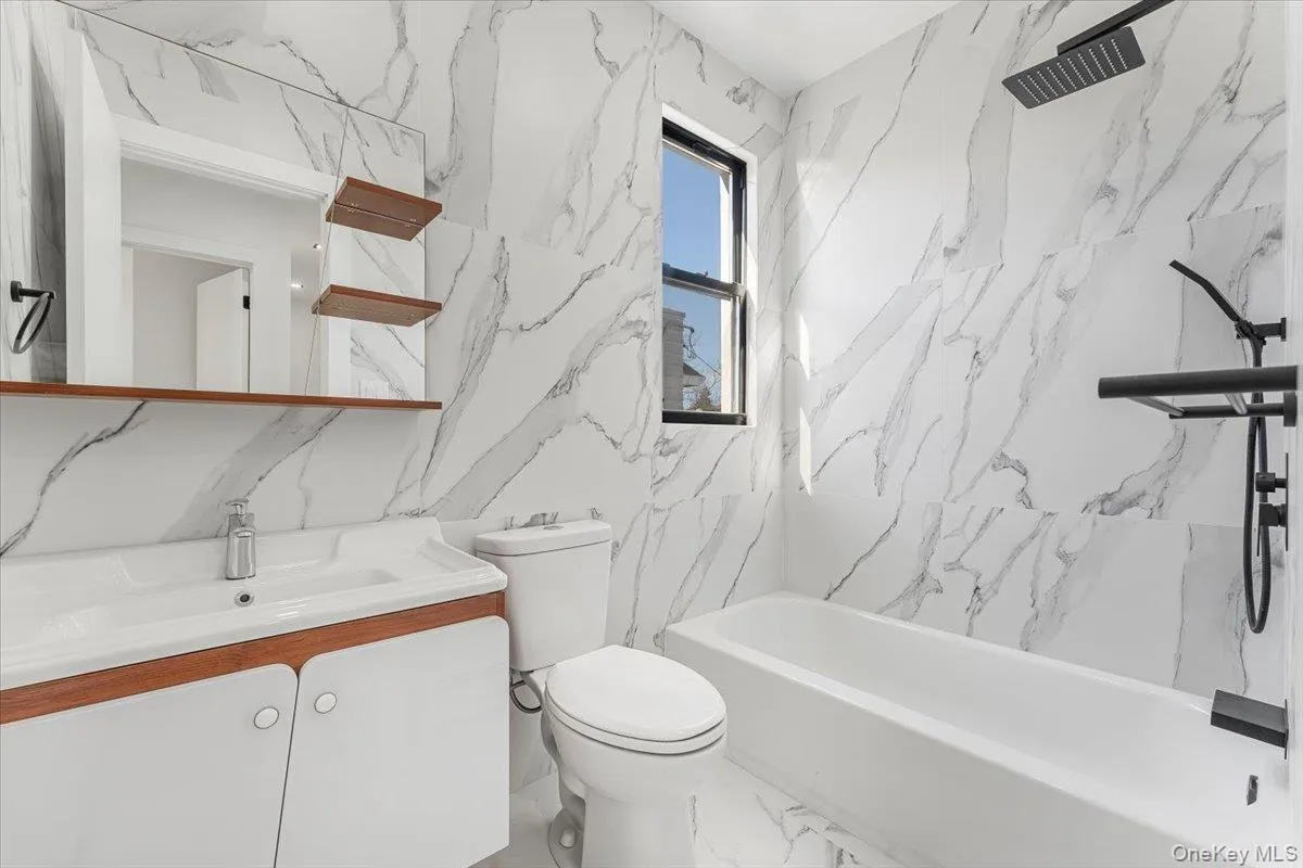 Full bathroom with stone wall, vanity, a combined bath / shower with marble appearance, and marble tiled flooring Full bathroom with stone wall, vanity, a combined bath / shower with marble appearance, and marble tiled flooring