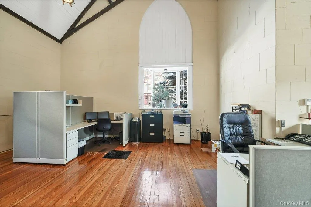 Office area featuring light wood-style floors and high vaulted ceiling Office area featuring light wood-style floors and high vaulted ceiling