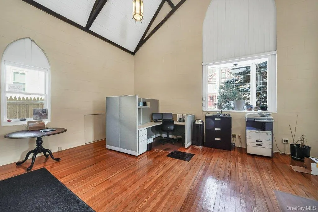Home office featuring light wood-style floors, high vaulted ceiling, and beamed ceiling Home office featuring light wood-style floors, high vaulted ceiling, and beamed ceiling