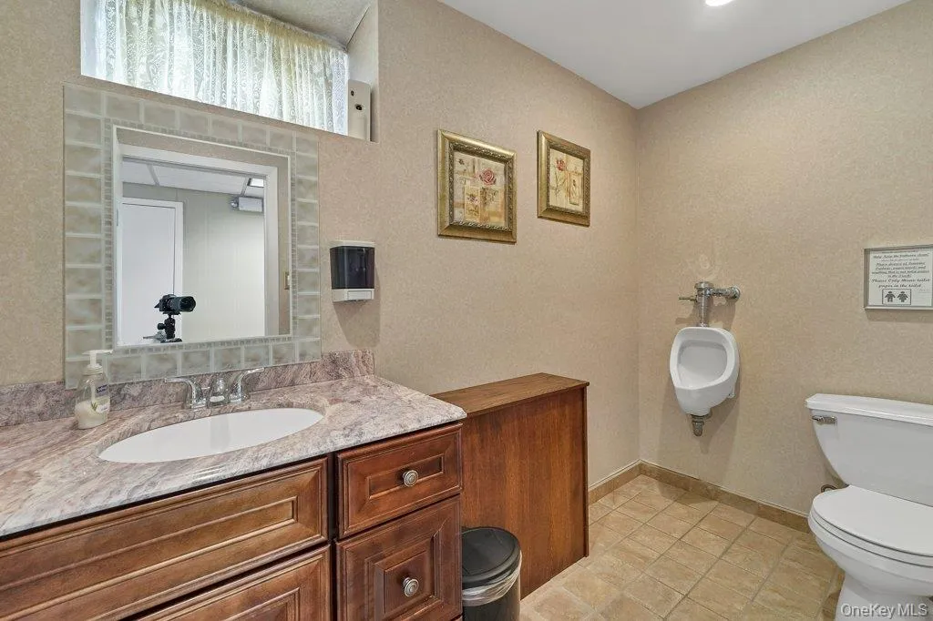 Half bathroom with light tile patterned flooring and vanity Half bathroom with light tile patterned flooring and vanity