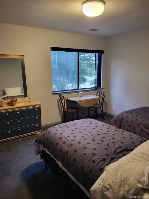 Bedroom featuring dark colored carpet and baseboards Bedroom featuring dark colored carpet and baseboards