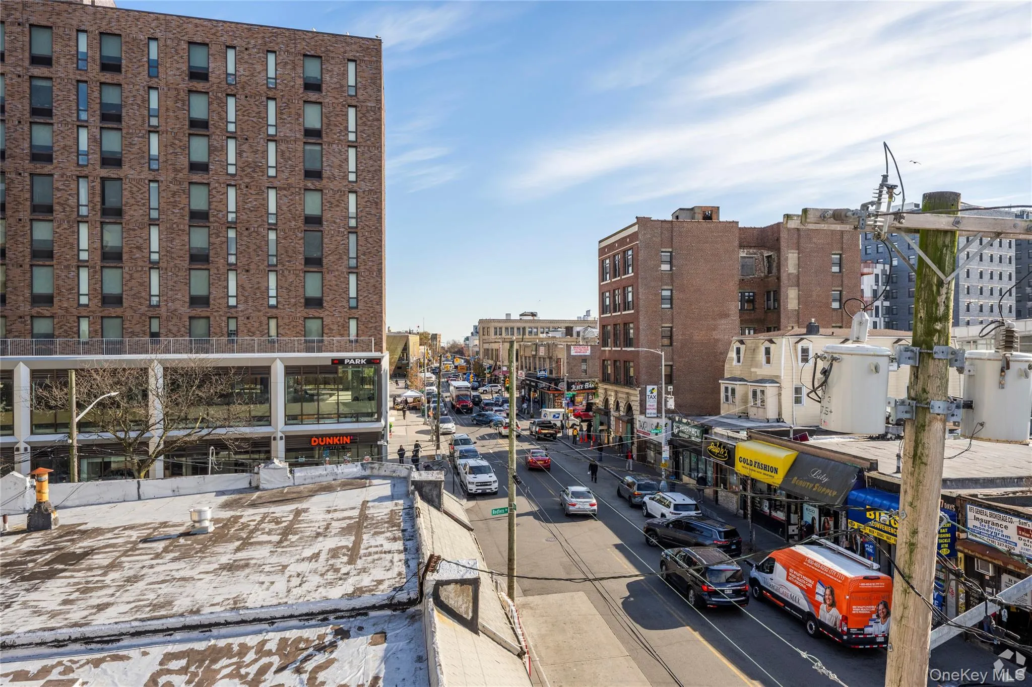 View of asphalt street featuring sidewalks, a city view, street lights, and curbs View of asphalt street featuring sidewalks, a city view, street lights, and curbs