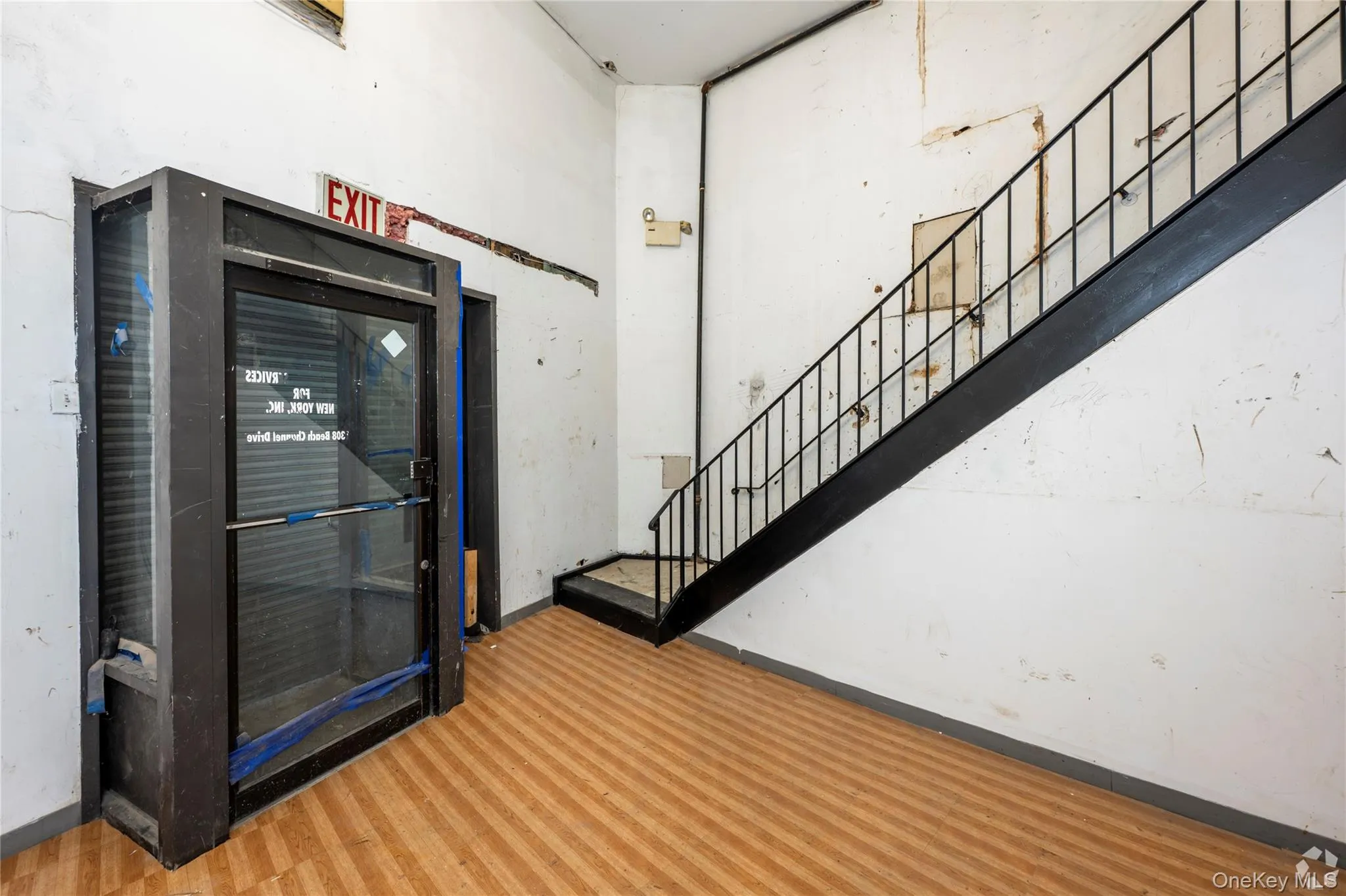 Foyer with wood finished floors, stairway, and a high ceiling Foyer with wood finished floors, stairway, and a high ceiling