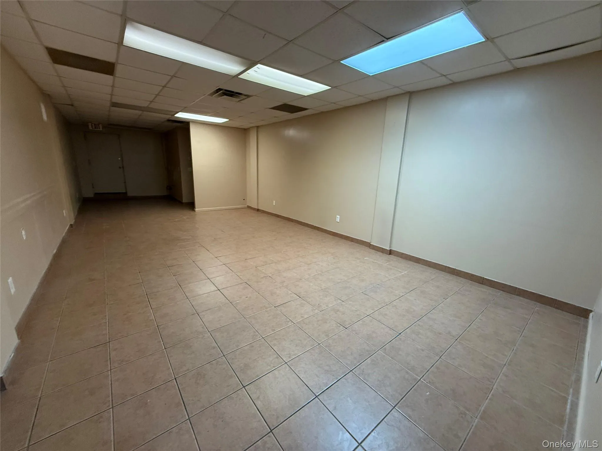Unfurnished room featuring a drop ceiling and light tile patterned floors Unfurnished room featuring a drop ceiling and light tile patterned floors