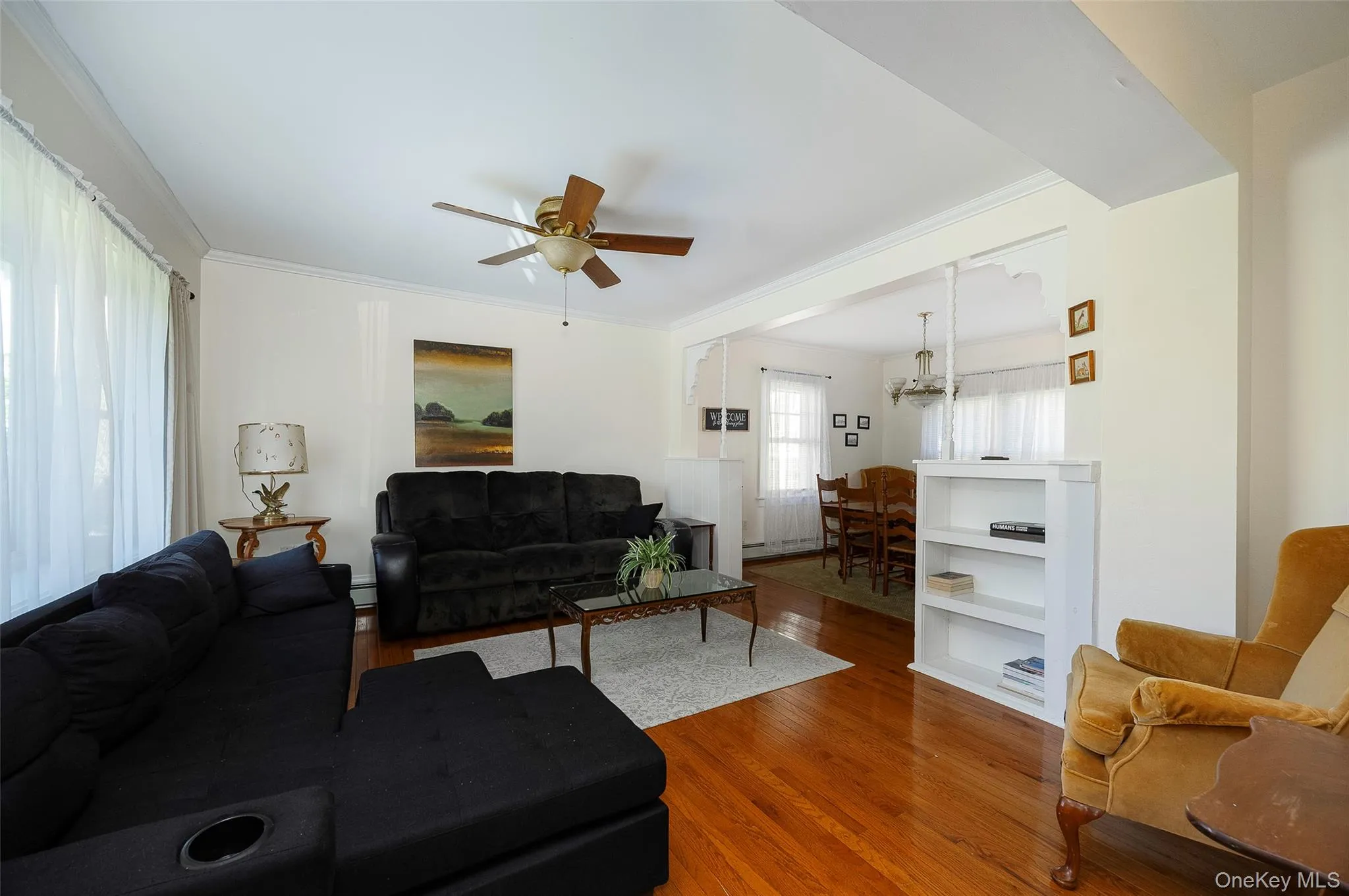 Living area with wood finished floors, a ceiling fan, and ornamental molding Living area with wood finished floors, a ceiling fan, and ornamental molding