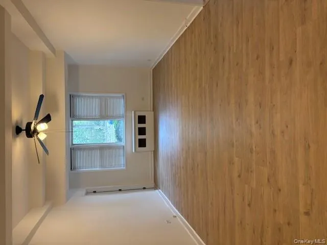 Empty room with light wood finished floors, ceiling fan, and beam ceiling Empty room with light wood finished floors, ceiling fan, and beam ceiling