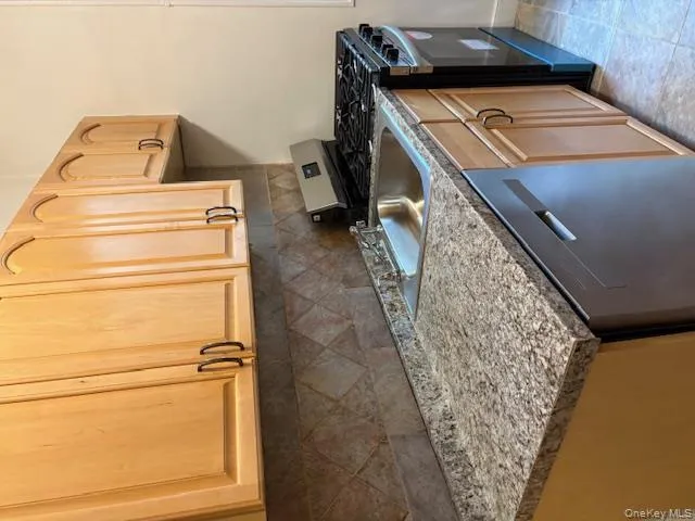 Kitchen featuring stainless steel range oven, light brown cabinets, dishwasher, and backsplash Kitchen featuring stainless steel range oven, light brown cabinets, dishwasher, and backsplash