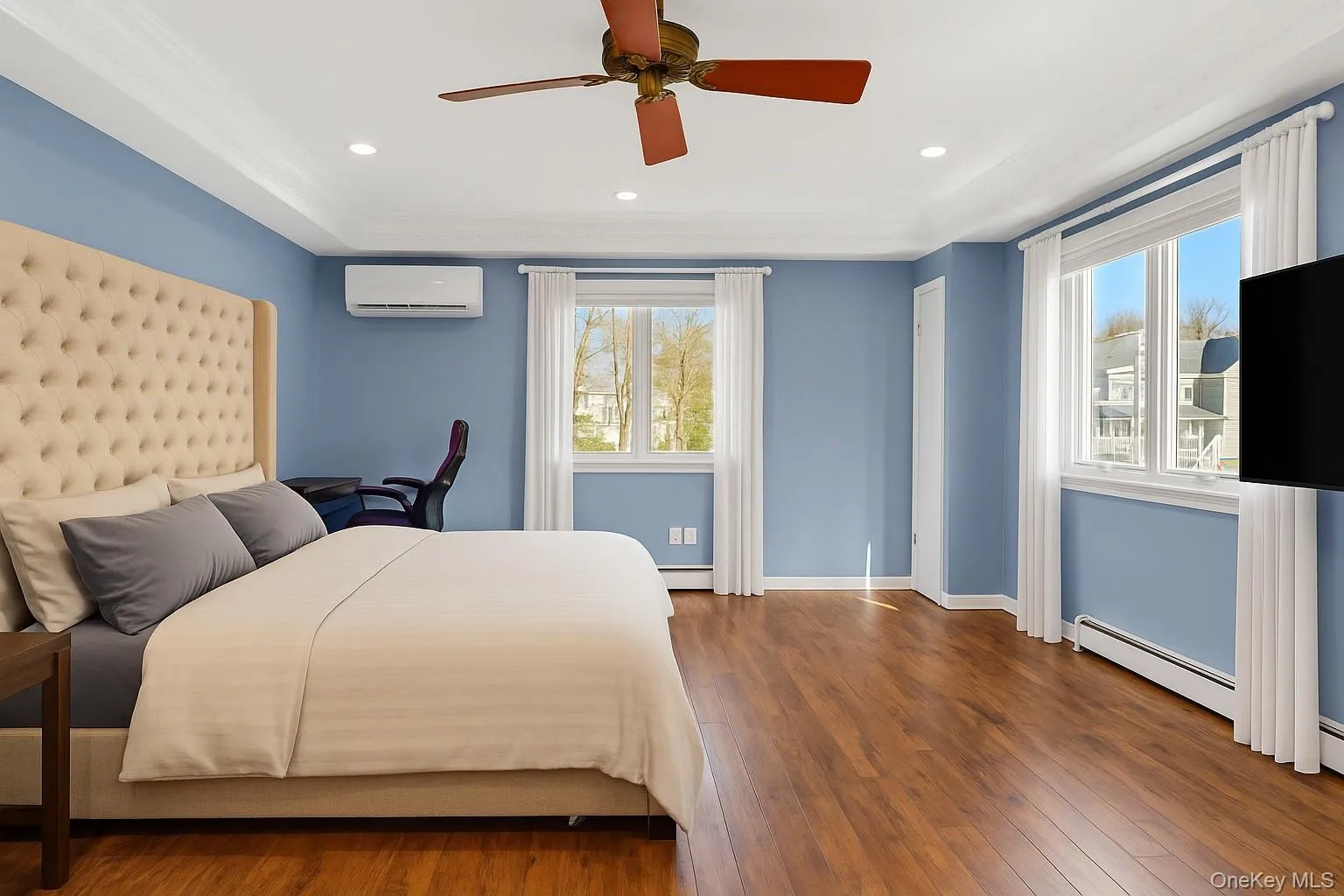Bedroom with a baseboard heating unit, wood-type flooring, a ceiling fan, recessed lighting, and an AC wall unit Bedroom with a baseboard heating unit, wood-type flooring, a ceiling fan, recessed lighting, and an AC wall unit
