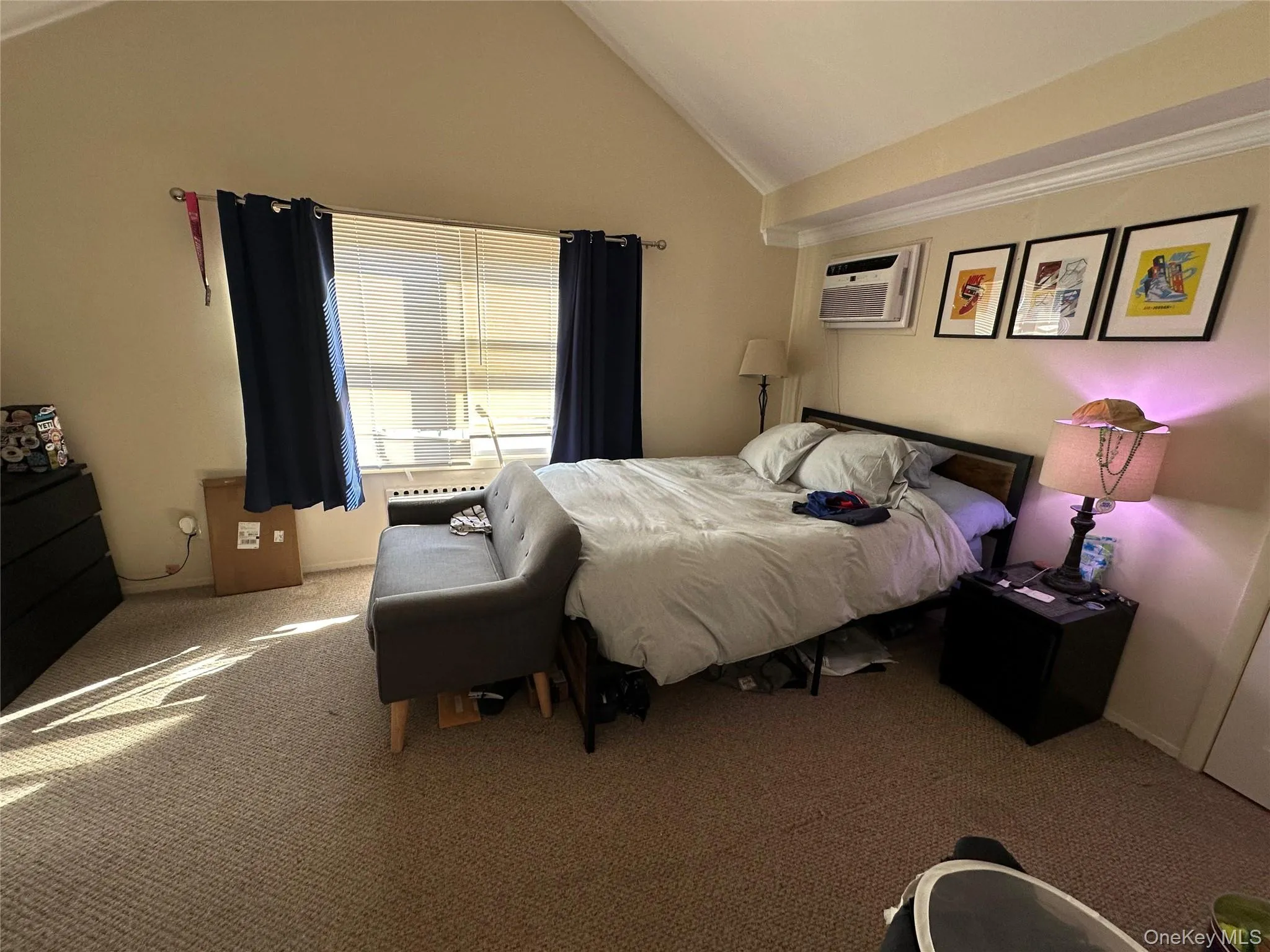 Bedroom featuring carpet flooring, vaulted ceiling, and an AC wall unit Bedroom featuring carpet flooring, vaulted ceiling, and an AC wall unit