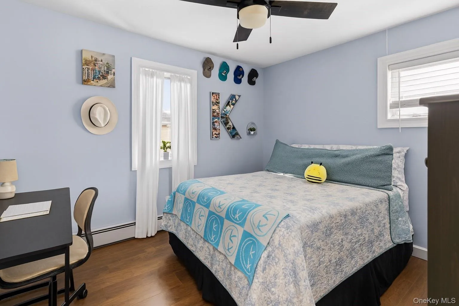 Bedroom with dark wood-style flooring, a ceiling fan, and baseboard heating Bedroom with dark wood-style flooring, a ceiling fan, and baseboard heating