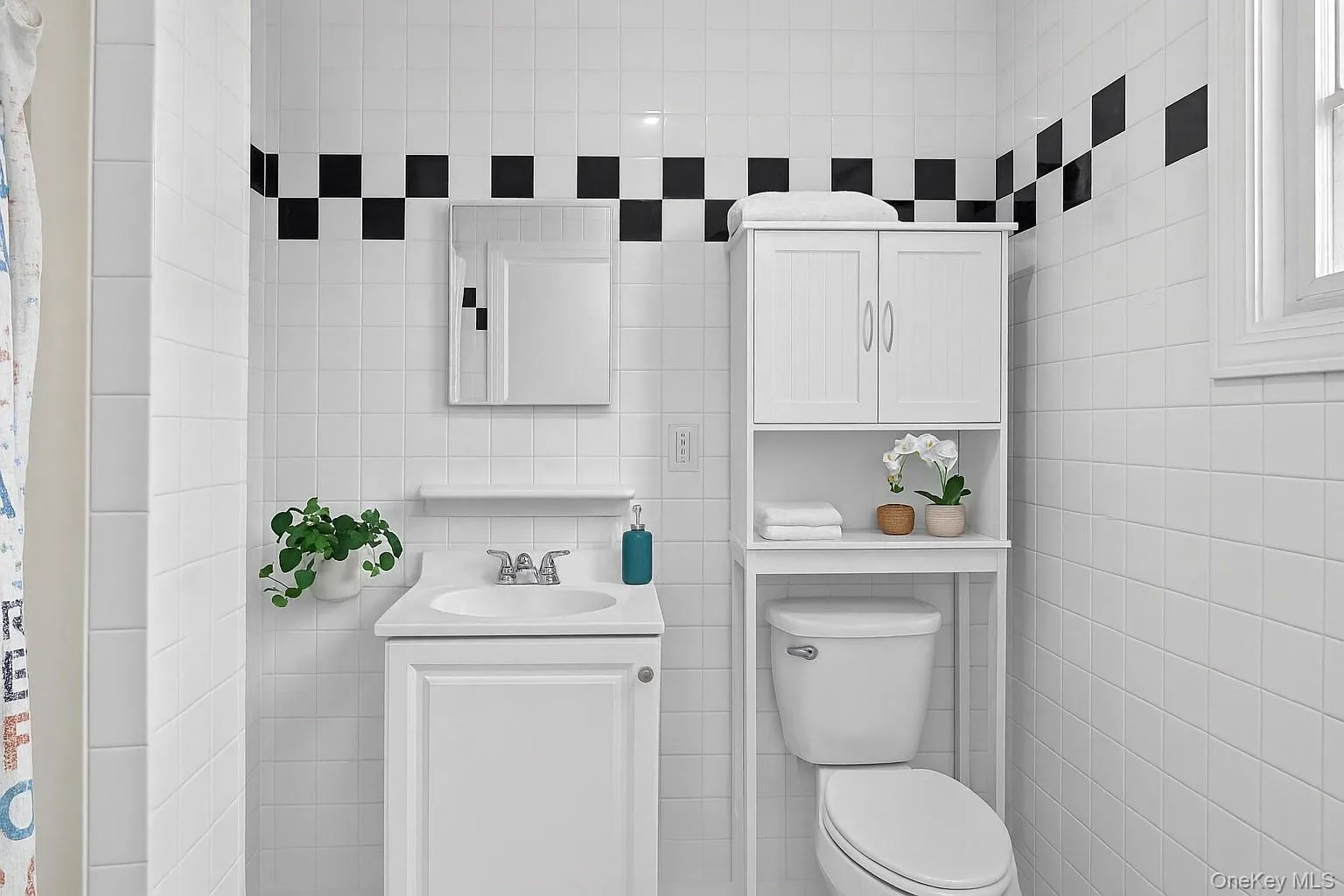 Bathroom with tile walls, vanity, and a shower with shower curtain Bathroom with tile walls, vanity, and a shower with shower curtain
