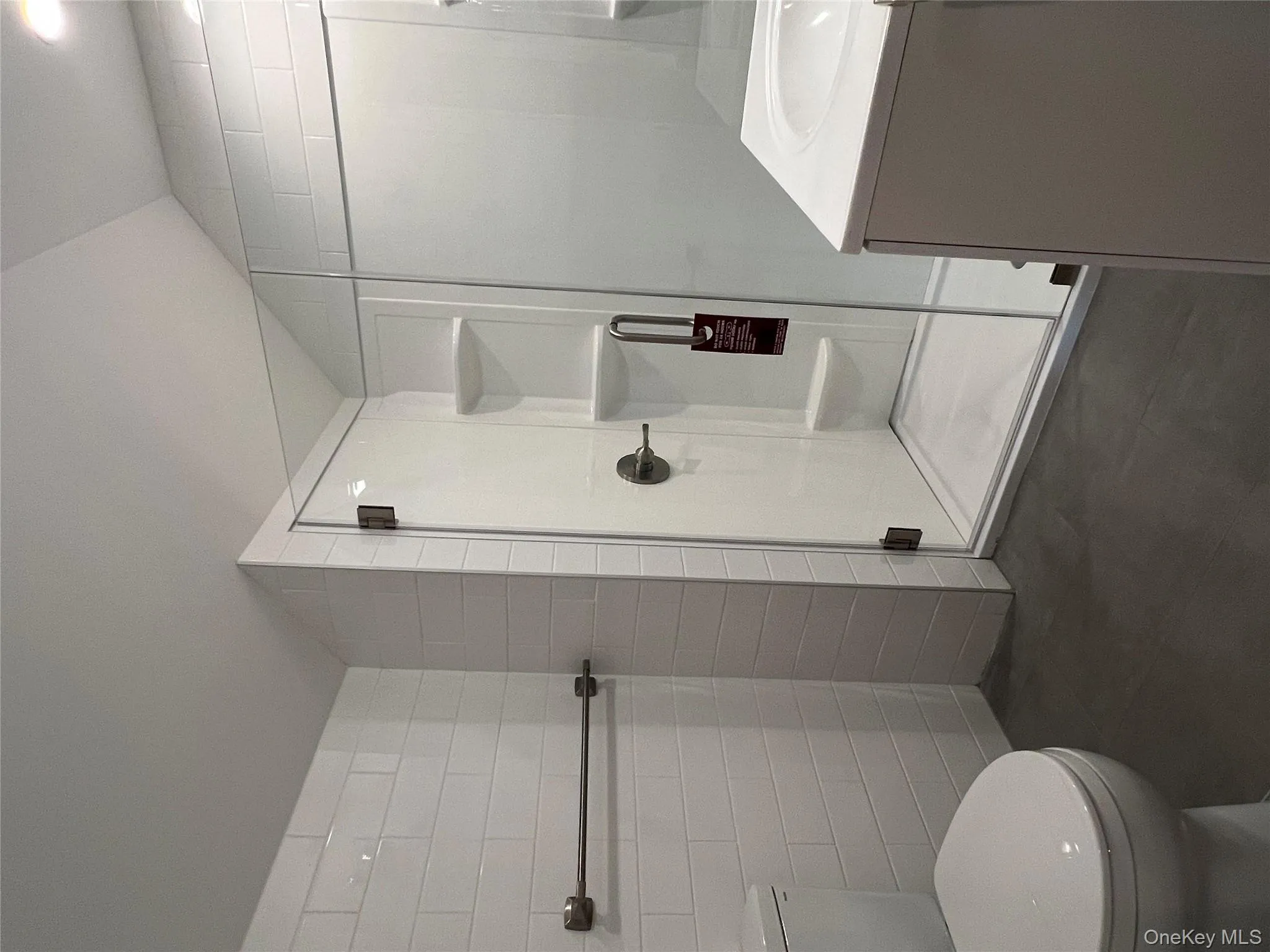 Full bath featuring a stall shower, vanity, and tile walls Full bath featuring a stall shower, vanity, and tile walls